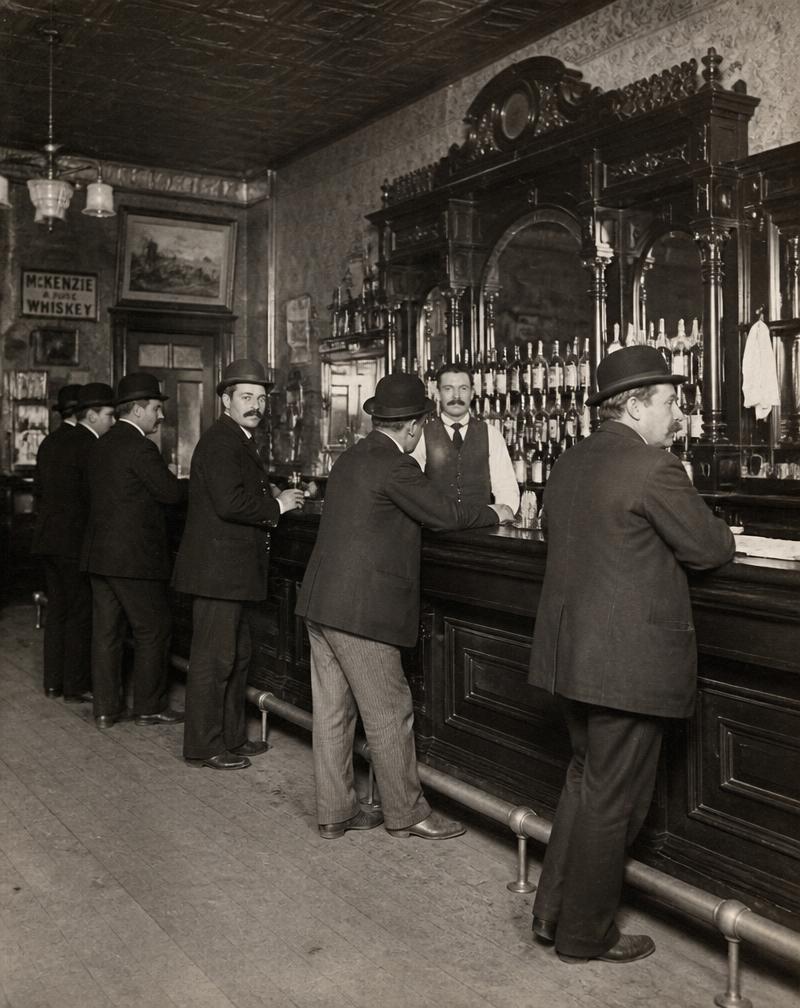 Archival photograph of an early 1900s saloon interior with patrons in bowler hats